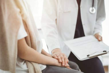 Doktor ve çocuk hasta. Hekim elinde bir dosya tutuyor ve bir çocuğu rahatlatıyor. Tıptaki ideal sağlık kavramı.