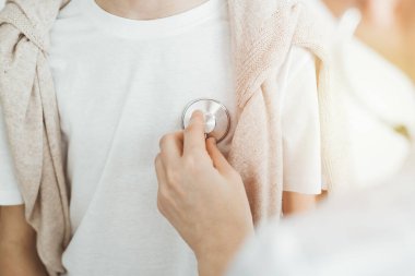 Doktor steteskoplu bir çocuk hastayı muayene ediyor. Tıpta mükemmel sağlık kavramı.