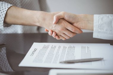 Ofisteki cam masada otururken sözleşmeyi imzalayan işadamları, yakın plan. Toplantıda ortaklar ya da avukatlar birlikte çalışıyor. Takım çalışması, ortaklık, başarı kavramı.