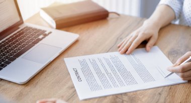 Ofisteki ahşap masada otururken sözleşmeyi imzalayan işadamları, yakın plan. Toplantıda ortaklar ya da avukatlar birlikte çalışıyor. Takım çalışması, ortaklık, başarı kavramı.