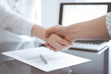 İş adamları sözleşme kağıtlarının üzerinde el sıkışıyorlar. Gri masaya yeni imzaladılar. Kapatın. Avukatlar ya da girişimciler toplantıda. Takım çalışması, ortaklık, başarı kavramı.