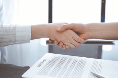 İş adamları sözleşme kağıtlarının üzerinde el sıkışıyorlar. Gri masaya yeni imzaladılar. Kapatın. Avukatlar ya da girişimciler toplantıda. Takım çalışması, ortaklık, başarı kavramı.