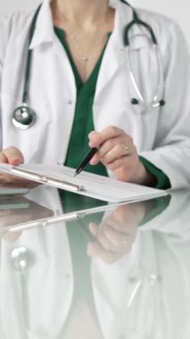 Female doctor in a hospital setting is pointing at medical chart, showcasing expertise in a close up shot. Medicine