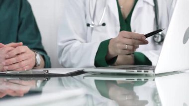 Kliniği, sağlık hizmetlerini ve tıbbi danışmanlık konseptini ziyaret eden bir hastaya dizüstü bilgisayarda muayene sonuçlarını gösteren kadın doktor.