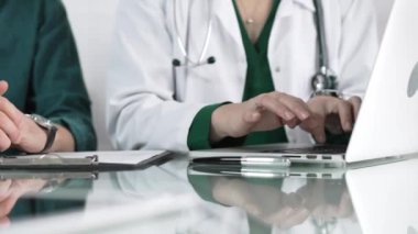 Kliniği, sağlık hizmetlerini ve tıbbi danışmanlık konseptini ziyaret eden bir hastaya dizüstü bilgisayarda muayene sonuçlarını gösteren kadın doktor.