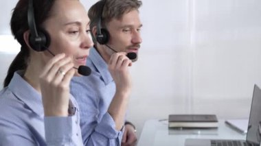 Mavi günlük bluzlu odaklı kadın çağrı merkezi operatörü müşterilerine çevrimiçi olarak yardım ediyor, müşteri desteği sağlıyor ve sorulara cevap veriyor. Çağrı merkezi kavramı.