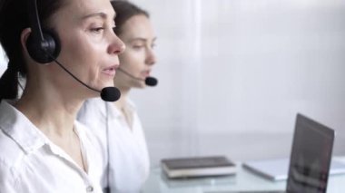 Müşterilere çevrimiçi olarak yardım eden, müşteri desteği sağlayan ve sorulara cevap veren kadın çağrı merkezi operatörleri. İş çağrı merkezi kavramı.