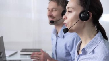 Mavi günlük bluzlu odaklı kadın çağrı merkezi operatörü müşterilerine çevrimiçi olarak yardım ediyor, müşteri desteği sağlıyor ve sorulara cevap veriyor. Çağrı merkezi kavramı.
