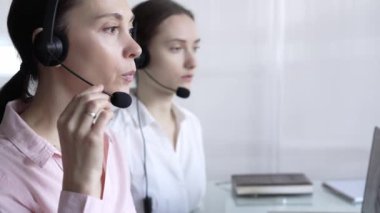 Pembe günlük gömlekli kadın çağrı merkezi operatörü müşterilerine çevrimiçi olarak yardım ediyor. Müşteri desteği sağlıyor ve sorulara cevap veriyor. İş çağrı merkezi.