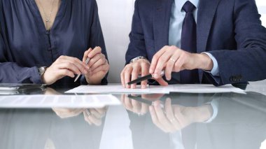 İş ortakları veya avukatlar bir toplantı sırasında sözleşme şartlarını gözden geçirir, müzakere eder ve birlikte kararlar alırlar. İş insanları kavramı, görünümü kapat.