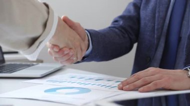 Şirket yöneticileri müzakereleri sonuçlandırıyor, modern konferans odasında sıkı tokalaşma ile profesyonel anlaşmayı imzalıyorlar. İş adamları konsepti