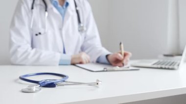 Mavi steteskopun yakın çekimi klinikteki panoda bayan doktor profesyonel yazısının yanında duruyor. Tıp ve sağlık hizmetleri kavramı.