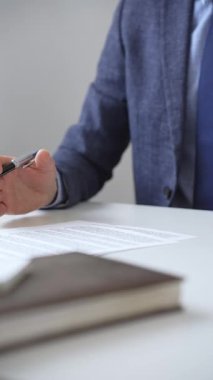 İş adamlarının el ele tutuşması ve bir ofis toplantısında önemli bir iş anlaşması imzalamaya hazırlanan bir sözleşmeyi gözden geçirmeleri. İş adamları konsepti