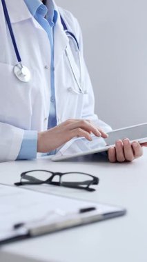 Laboratuvar önlüğü ve steteskop giyen kadın doktor, modern sağlık teknolojisini sergilemek için bilgisayarlı tablet kullanıyor. Tıp konsepti.