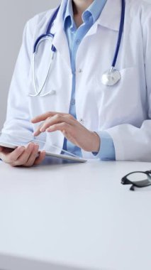 Laboratuvar önlüğü ve steteskop giyen kadın doktor, modern sağlık teknolojisini sergilemek için bilgisayarlı tablet kullanıyor. Tıp konsepti.