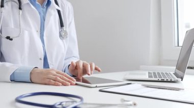 Laboratuvar önlüğü ve steteskop giyen kadın doktor, modern sağlık teknolojisini sergilemek için bilgisayarlı tablet kullanıyor. Tıp konsepti.