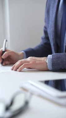 Profesyonel işadamı lüks kalemle yasal belge imzalıyor. Minimalist çalışma alanında özel dikim mavi takım elbise ve klasik kol saati takıyor. İş adamları konsepti