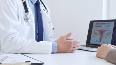 Doktor hastayla dijital test sonuçlarını gözden geçiriyor, klinik konsültasyon sırasında laptopta sağlık bulgularını tartışıyor. İlaç ve sağlık hizmetleri kavramı