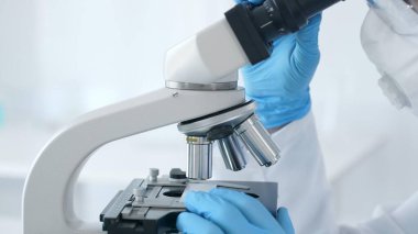 Mikroskobu kapat ve bilim adamları laboratuarda ayarlayan mavi eldivenleri teslim et. Tıp, bilim konsepti.