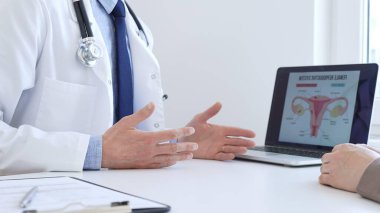 Doktor hastayla dijital test sonuçlarını gözden geçiriyor, klinik konsültasyon sırasında laptopta sağlık bulgularını tartışıyor. İlaç ve sağlık hizmetleri kavramı