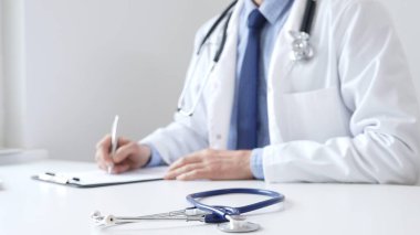 Mavi steteskop, klinikteki panoda, profesyonel doktor yazısının yanında duruyor. İlaç ve sağlık hizmetleri.