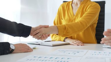 Profesyonel iş adamları el sıkışıyor, günümüzün güneşli ofisindeki ortaklık anlaşmasını onaylıyorlar. İş tokalaşması.