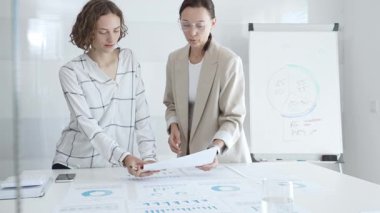 Finansal belgeleri inceleyen, çağdaş kurumsal çalışma alanında birlikte çalışan, iş geliştirme planlarına odaklanan profesyonel kadınlar. İş adamları konsepti