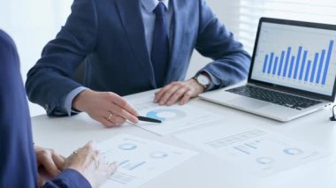 Bir dizüstü bilgisayarda finansal verileri tartışan çok sayıda iş arkadaşından oluşan bir ekip, görevdeki grafikleri ve pazar eğilimlerini analiz ediyor. İş adamları ve finans kavramı.