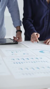 Verimli bir toplantı, işbirliği ve stratejinin geliştirilmesi sırasında mali verileri, grafikleri ve grafikleri inceleyen iş arkadaşları.