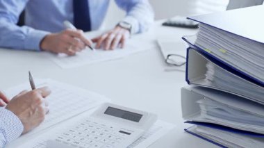 Finans uzmanları evrakları inceliyor, verileri analiz ediyor ve takım toplantılarında mali stratejileri tartışıyor. İş dünyasında denetim ve vergi teması