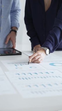 Verimli bir toplantı, işbirliği ve stratejinin geliştirilmesi sırasında mali verileri, grafikleri ve grafikleri inceleyen iş arkadaşları.