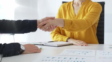 Başarılı bir toplantının ardından iş ortaklarının el sıkışması, şık, modern ofis ortamında bir iş anlaşmasının veya sözleşmenin sağlamlaştırılması