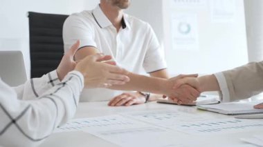 İki iş kadını başarılı bir toplantının ardından birbirleriyle tokalaşırlar, parlak, modern ofis ortamında bir iş anlaşmasını sağlamlaştırırlar. El sıkışma kavramı.