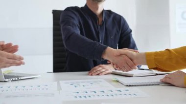 İş adamı, iş yeri belgeleri üzerinde kadın partnerle tokalaşıyor, işbirlikçi ruhu simgeliyor ve işyerindeki başarıyı paylaşıyor. İş konsepti.