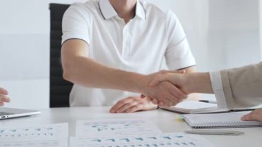 İş adamı başarılı bir toplantının ardından bir iş kadınıyla tokalaşıyor, şık ve modern bir ofis ortamında bir iş anlaşmasını sağlamlaştırıyor. El sıkışma kavramı.