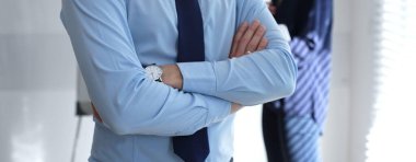 Resmi gömlekli ve kravatlı profesyonel bir iş adamı, bir ofis toplantısında kolları bağlı, liderlik, profesyonellik ve kurumsal güvene odaklanıyor.