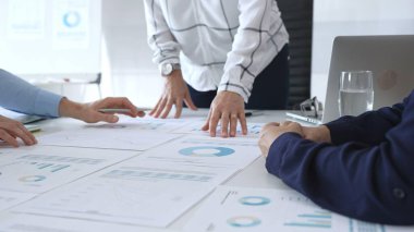 Ofis masasında çizelgeleri, grafikleri ve finansal veri tablolarını inceleyen bir grup profesyonel. Takım çalışması, strateji, iş planlaması ve kurumsal karar verme kavramı