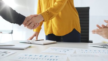 Profesyonel iş adamları el sıkışıyor, günümüzün güneşli ofisindeki ortaklık anlaşmasını onaylıyorlar. İş tokalaşması.