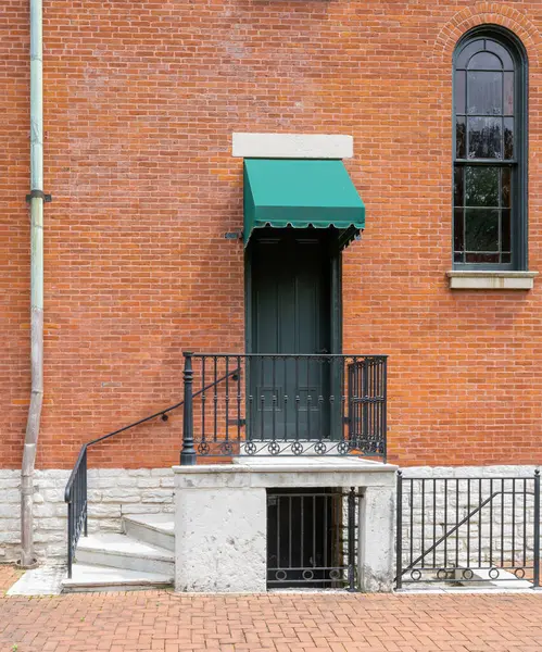 Binasında yeşil tente olan kapı.