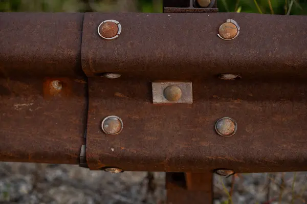 stock image Rusty guardrail with rivets along side a old road