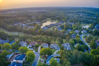 Aerial panoramic view of house cluster in a sub division in Suburbs with golf course and lake in metro Atlanta in Georgia ,USA clipart