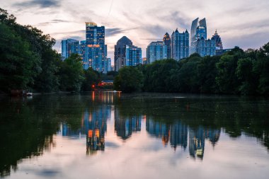 Atlanta, GA: 25 Eylül 2023 - Atlanta ufuk çizgisinin panoramik görüntüsü ve günbatımı çekimleri sırasında Piedmont Park 'tan Clara Meer Gölü ve Altın Saat Ortası Kasabası manzaralı gökyüzü
