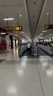 Yeni Delhi, Hindistan: 15 Mart 2024: Havaalanı terminalinin kalkış kapısında uçağa binmek için bekleyen yolcular