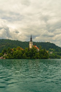 Slovenya 'da Bled Gölü, Kan Kanı Kilisesi ve Julian Alpleri' nin panoramik manzarası yemyeşil yemyeşil ormanlarla dolu