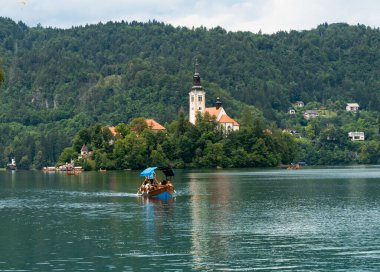 Slovenya 'da Bled Gölü, Kan Kanı Kilisesi ve Julian Alpleri' nin panoramik manzarası yemyeşil yemyeşil ormanlarla dolu