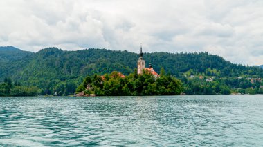 Slovenya 'da Bled Gölü, Kan Kanı Kilisesi ve Julian Alpleri' nin panoramik manzarası yemyeşil yemyeşil ormanlarla dolu