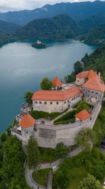  Bled Gölü (Blejsko Jezero) ile güzel Kanlı Kale 'nin (Blejski Grad) havadan panoramik görüntüsü, Maria' nın Hükmü Kilisesi ve Julian Alpleri 'nin üzerine bulutlu bir gökyüzü.