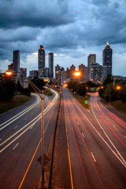 Atlanta ufuk çizgisinin panoramik görüntüsü günbatımında fırtına bulutları, uzun pozlama ve ABD 'nin Atlanta şehir merkezindeki eski dördüncü bölgeden gelen ışık yolları ile çekilmiştir.