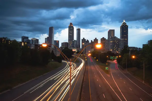 Atlanta ufuk çizgisinin panoramik görüntüsü günbatımında fırtına bulutları, uzun pozlama ve ABD 'nin Atlanta şehir merkezindeki eski dördüncü bölgeden gelen ışık yolları ile çekilmiştir.