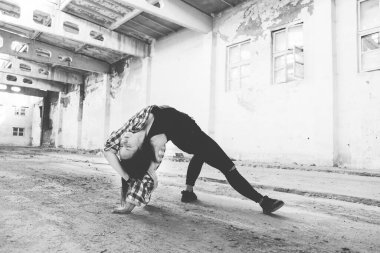 Breakdance akrobatik elementleri sergiler. Eski endüstriyel binada hip-hop yapan kız. Genç kız sanat dansı. Sokak şehir yaşam tarzı.